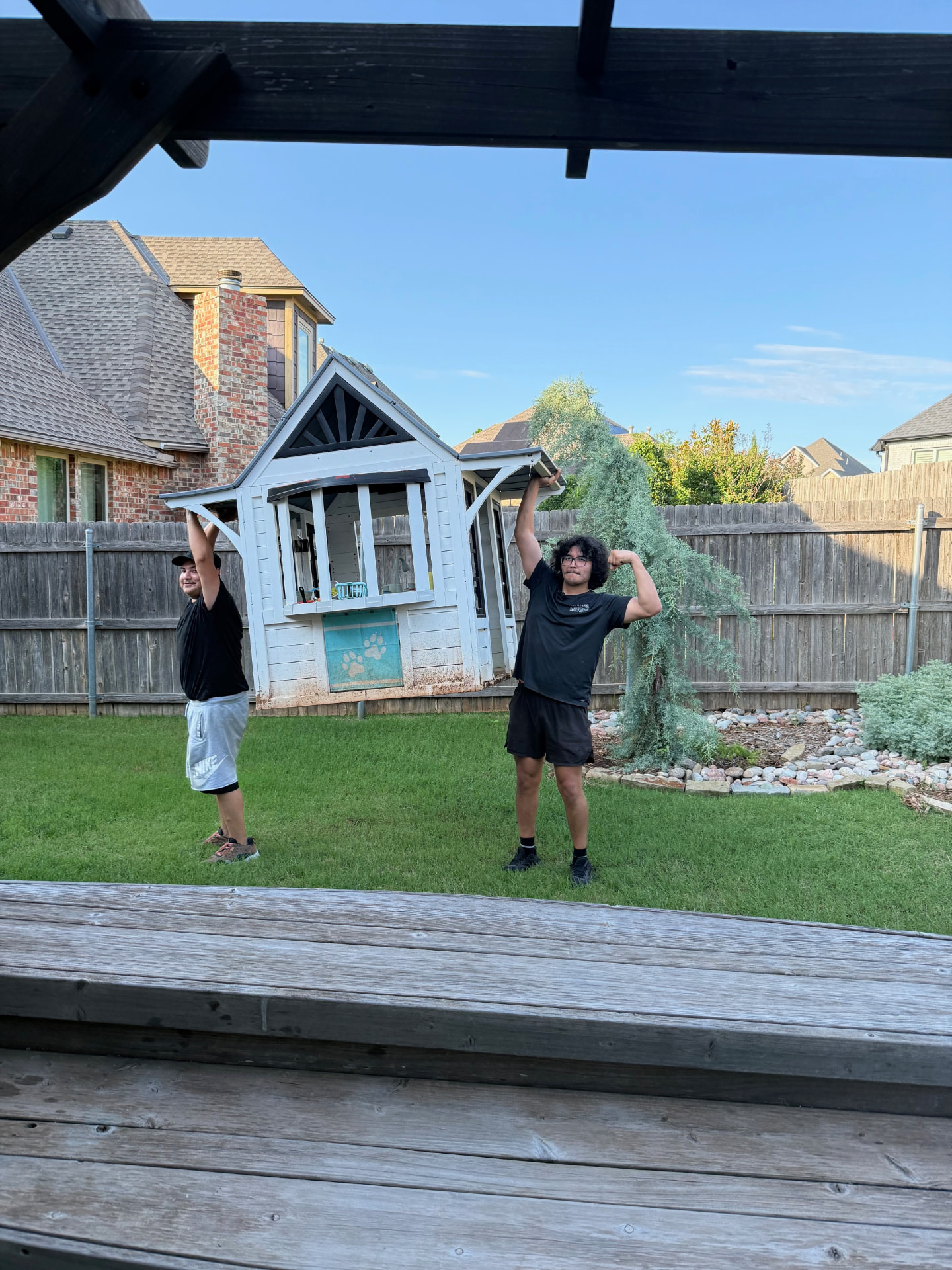 Two Top Dawg movers carrying a backyard playhouse during a residential move near Bethany, OK